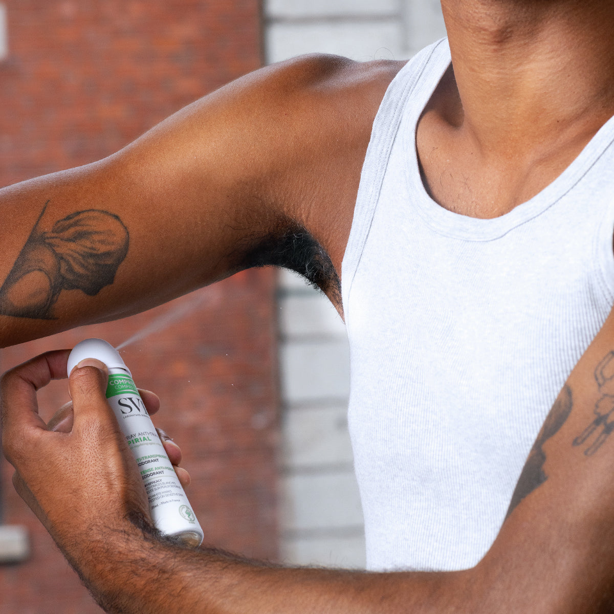 Persona che applica lo spray antitraspirante SVR Spirial bianco e verde sotto l'ascella per una protezione 48 ore.