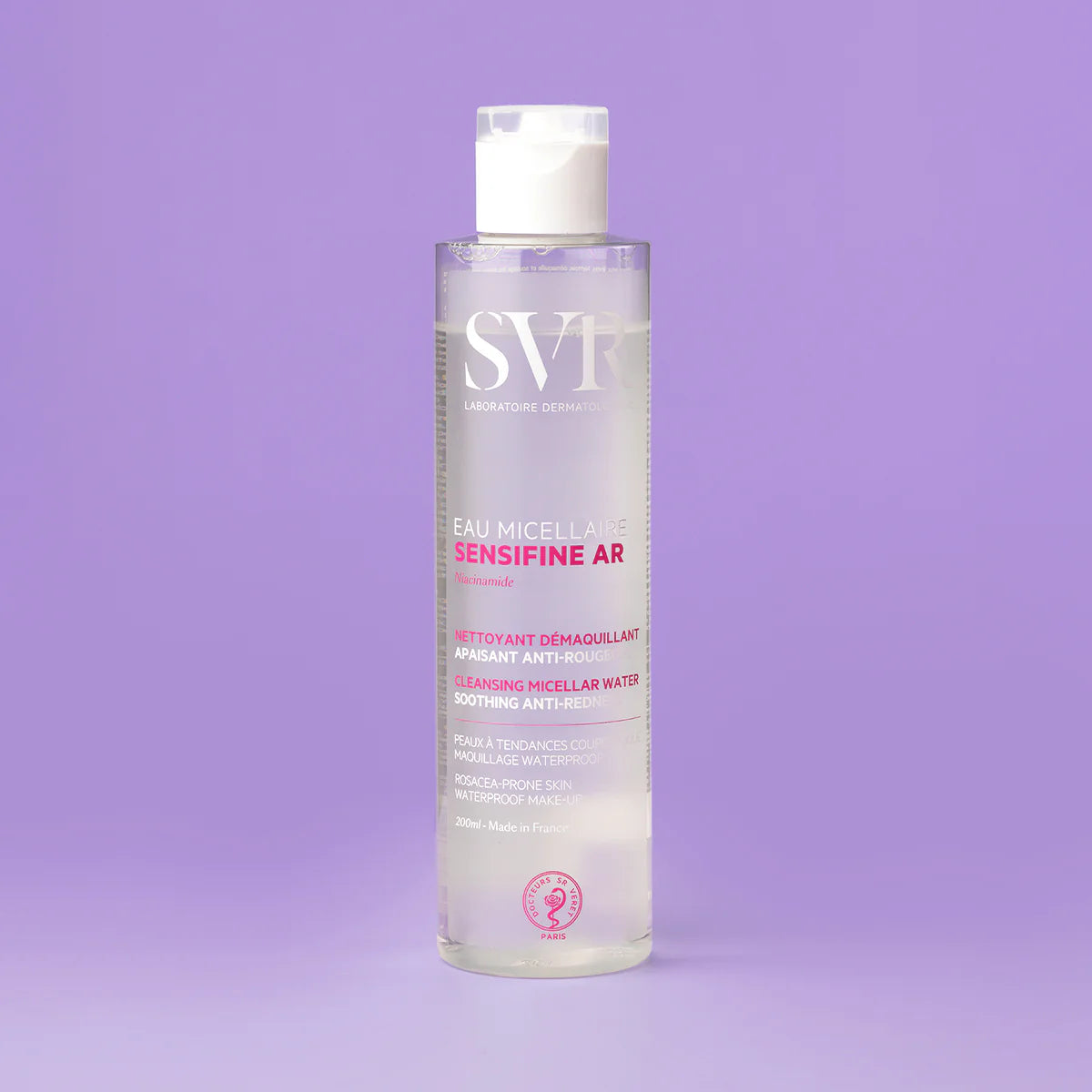 Flacone trasparente di SVR Sensifine AR Eau Micellaire da 200ml con tappo bianco su sfondo viola.