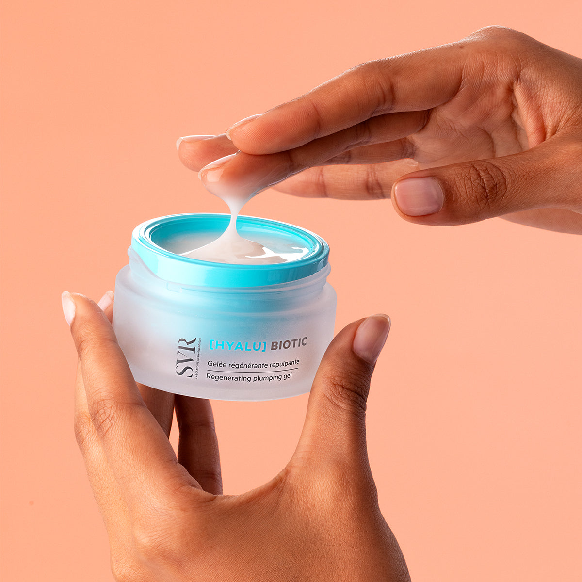 Vasetto di gel-crema SVR Hyalu Biotic con tappo azzurro tenuto tra le mani, mostrando la texture leggera e idratante del prodotto.