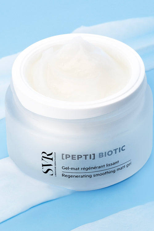 Vasetto in vetro satinato di SVR [PEPTI] Biotic con gel rigenerante bianco su sfondo azzurro con texture cremosa.
