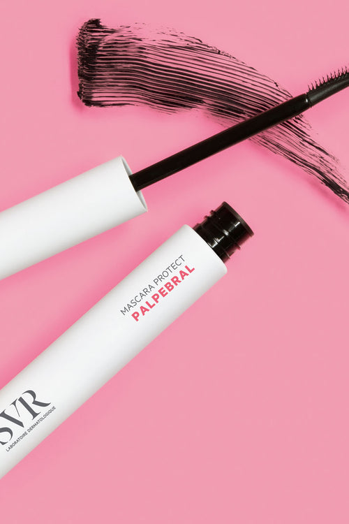 Mascara nero SVR Palpebral Protect con applicatore e tratto di colore su sfondo rosa.