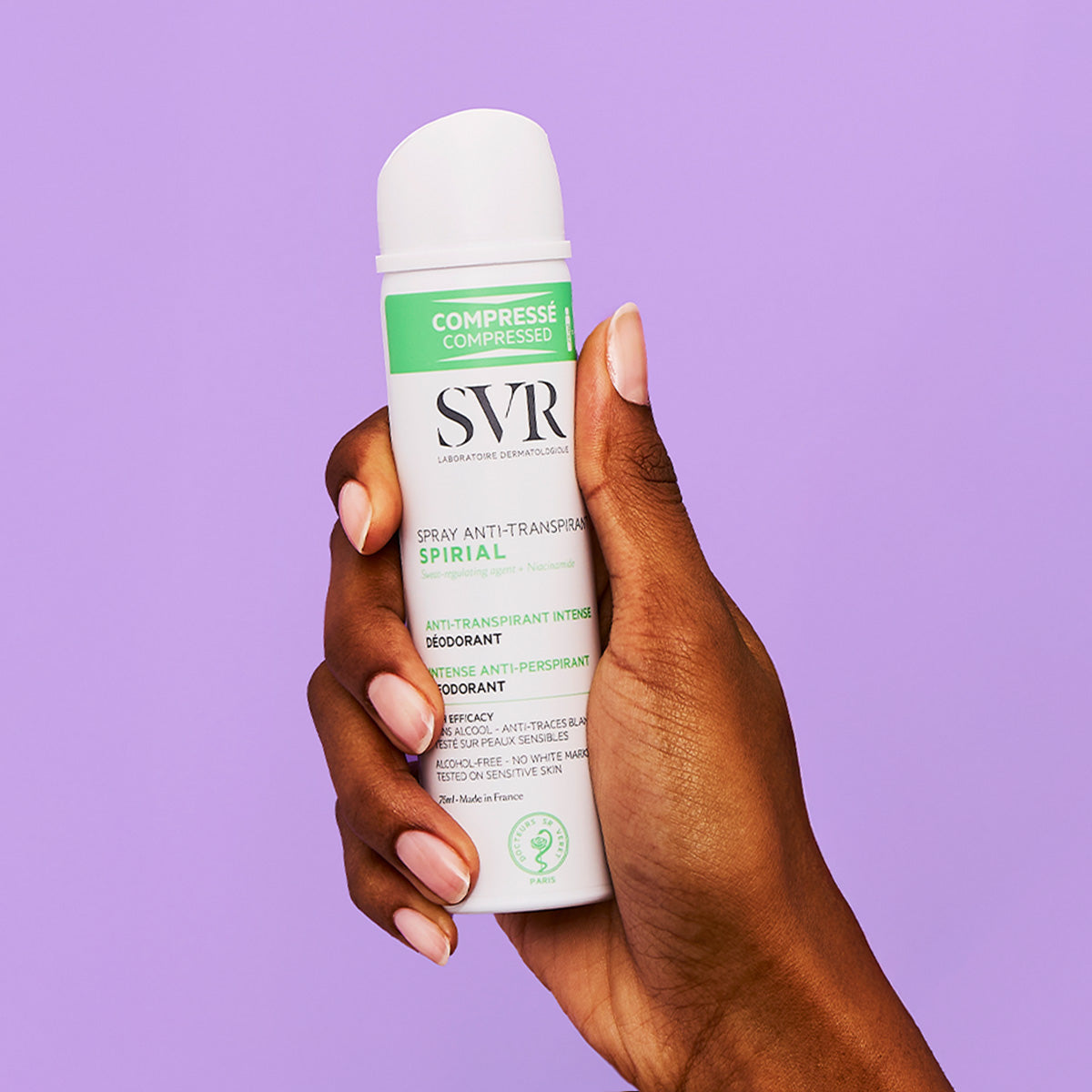 Mano che tiene una bomboletta spray SVR Spirial bianca e verde su sfondo viola.