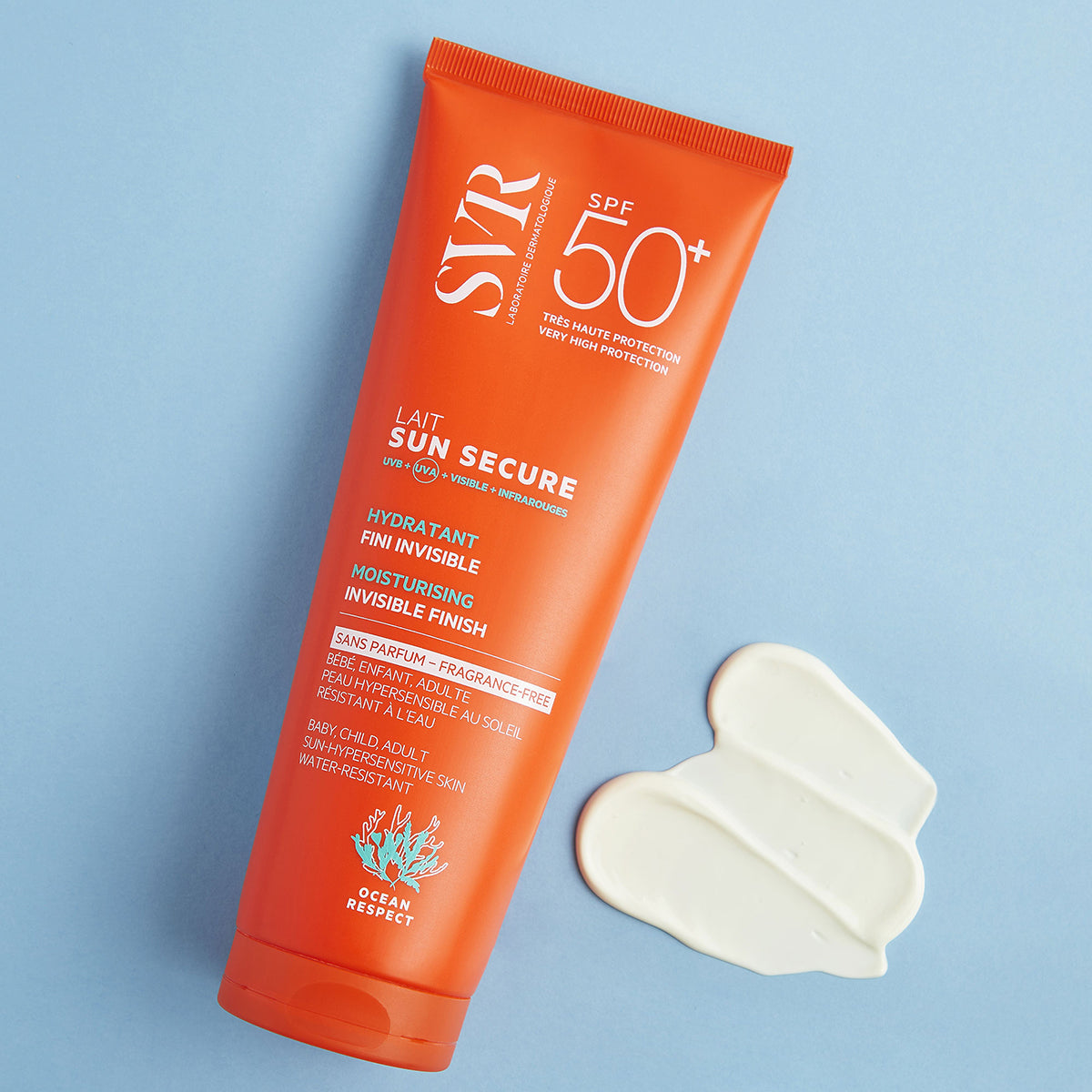 Tubo arancione di crema solare SVR Sun Secure SPF50+ con una goccia di latte bianco su sfondo azzurro.
