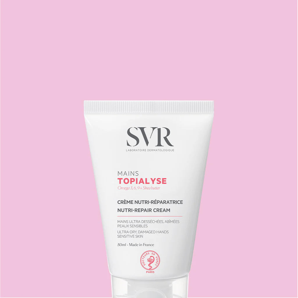 Tubo bianco di crema mani SVR Topialyse da 50ml su sfondo rosa, trattamento nutriente e riparatore per pelli secche.