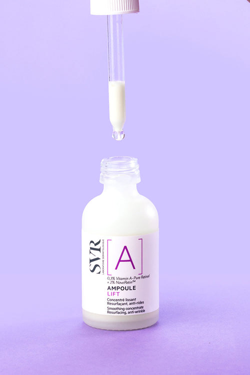 Flacone di SVR Ampoule Lift con contagocce che rilascia una goccia di siero bianco su sfondo lilla.