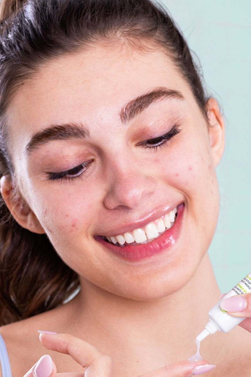 Smiling woman applying clear SVR Sebiaclear Gel Flash 4H from a white squeeze tube onto her fingertip.
